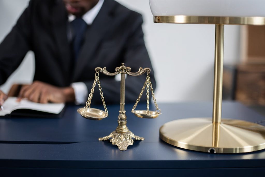 pexels-photo-6077861 Elegant legal office with a close-up of golden scales of justice on a sleek dark desk.